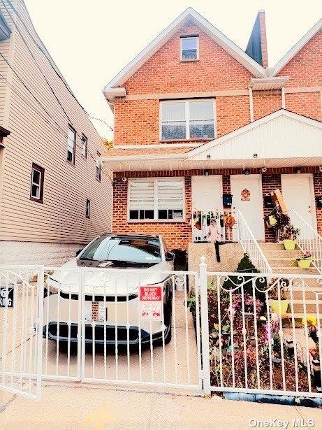 view of front of property featuring a fenced front yard, a gate, and brick siding