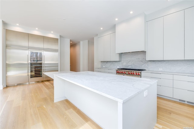 kitchen with modern cabinets, light wood-type flooring, range with two ovens, and a center island