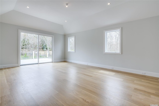 empty room with baseboards, lofted ceiling, recessed lighting, and light wood finished floors