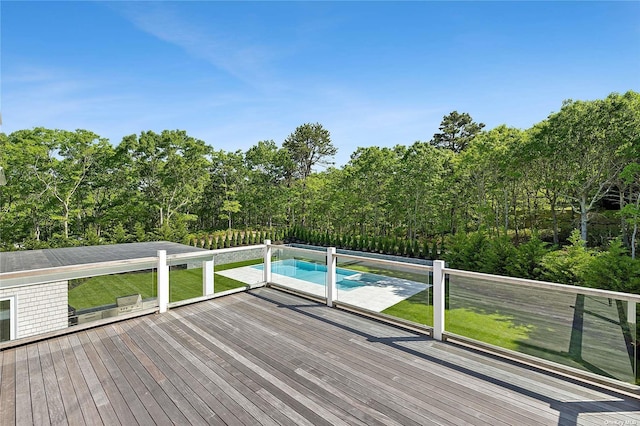 deck featuring a lawn and a fenced in pool