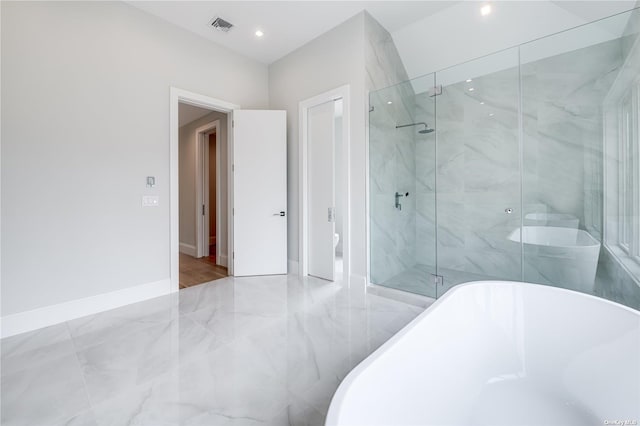 full bathroom featuring a marble finish shower, baseboards, visible vents, and a soaking tub