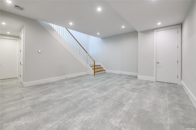 finished basement featuring baseboards, stairs, visible vents, and recessed lighting