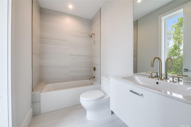 bathroom featuring toilet, vanity, and bathing tub / shower combination