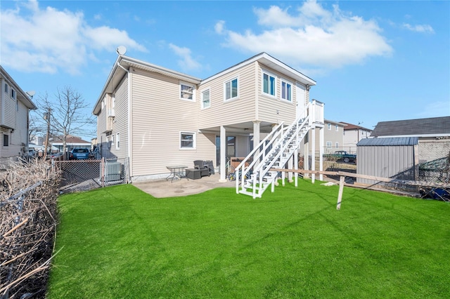 back of property with an outbuilding, a lawn, a patio area, a shed, and a fenced backyard