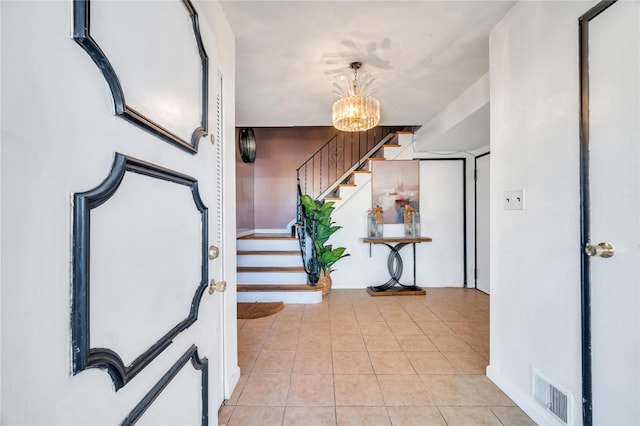 entrance foyer with light tile patterned floors, visible vents, an inviting chandelier, and stairs