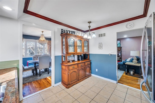 dining space featuring a chandelier, visible vents, ornamental molding, and light tile patterned floors