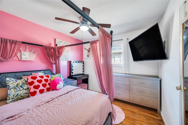 bedroom featuring a ceiling fan, baseboards, and wood finished floors