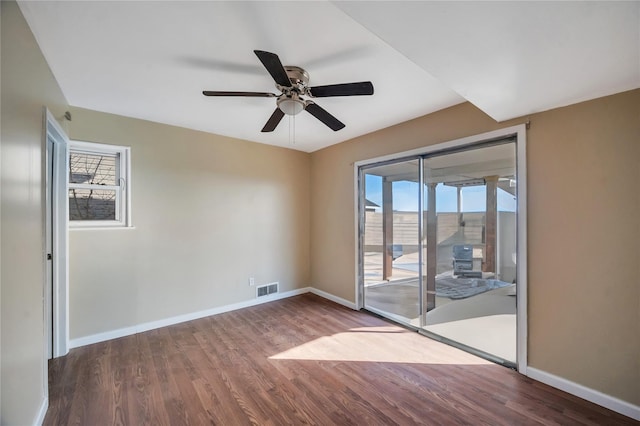 unfurnished room featuring visible vents, plenty of natural light, and wood finished floors