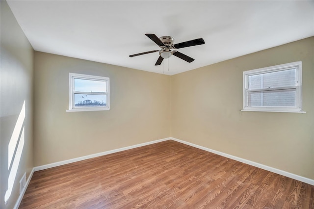 spare room with a ceiling fan, baseboards, and wood finished floors