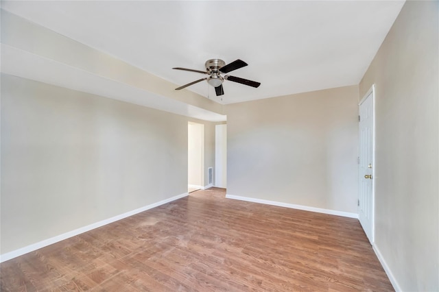 empty room with a ceiling fan, light wood-type flooring, and baseboards