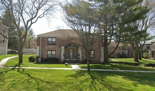 view of front of property with a front lawn and brick siding