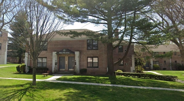 view of front facade with a front yard and brick siding