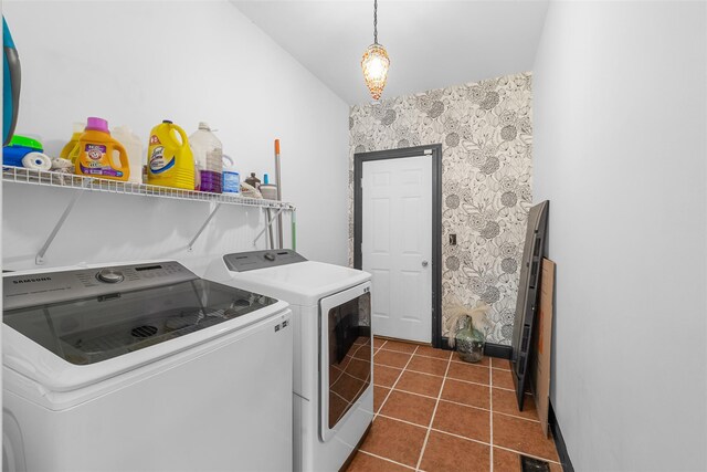 laundry area with laundry area, dark tile patterned floors, visible vents, and washer and clothes dryer