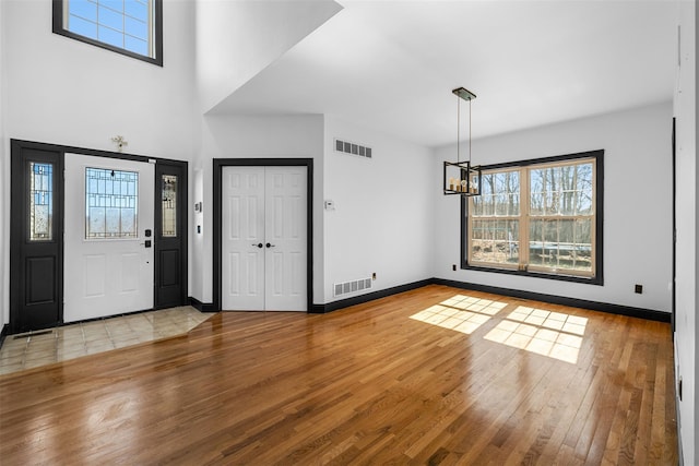 foyer entrance with visible vents, baseboards, and hardwood / wood-style flooring