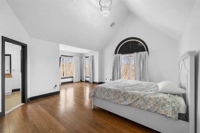 bedroom with visible vents, multiple windows, high vaulted ceiling, and hardwood / wood-style floors