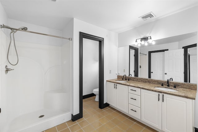 bathroom featuring a stall shower, toilet, visible vents, and a sink