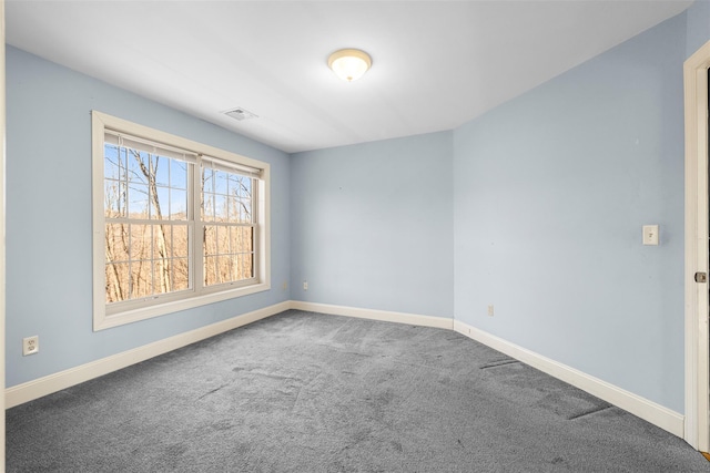 empty room featuring carpet flooring, visible vents, and baseboards