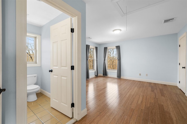 bathroom featuring visible vents, toilet, baseboards, and wood finished floors