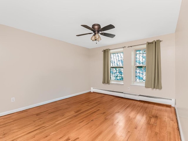 unfurnished room with a baseboard heating unit, ceiling fan, baseboards, and light wood-style floors