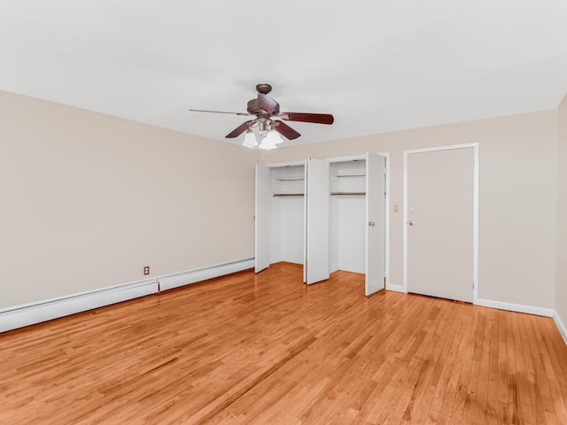 unfurnished bedroom featuring baseboards, a ceiling fan, light wood-type flooring, a baseboard heating unit, and multiple closets