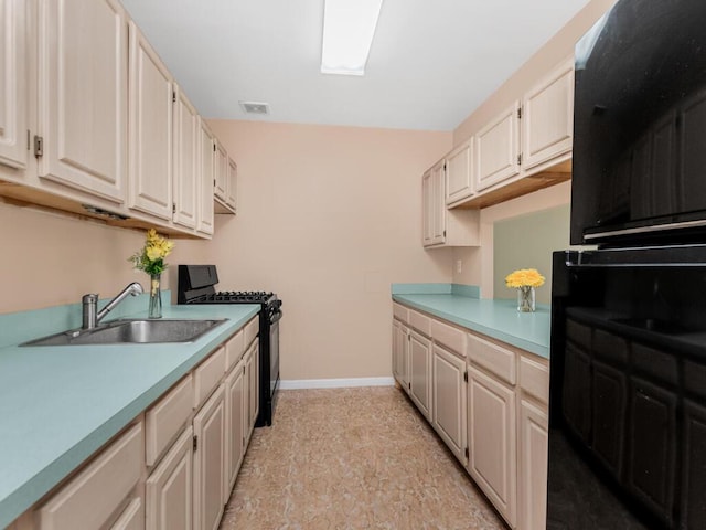 kitchen with black gas range, baseboards, visible vents, light countertops, and a sink