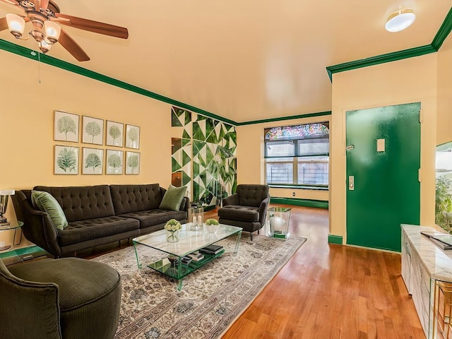 living area featuring a ceiling fan, ornamental molding, and wood finished floors