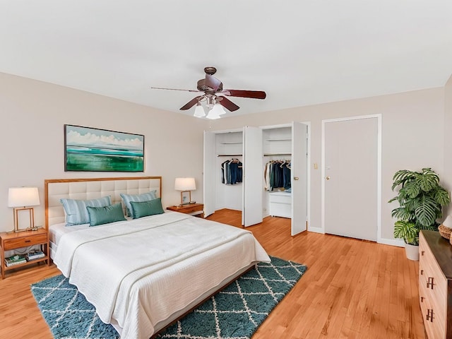 bedroom featuring ceiling fan, light wood-type flooring, two closets, and baseboards