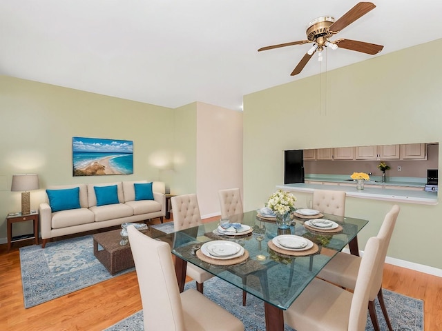 dining space with lofted ceiling, light wood-style floors, baseboards, and a ceiling fan