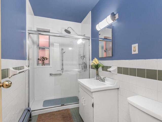 full bathroom featuring tile walls, toilet, a stall shower, wainscoting, and vanity