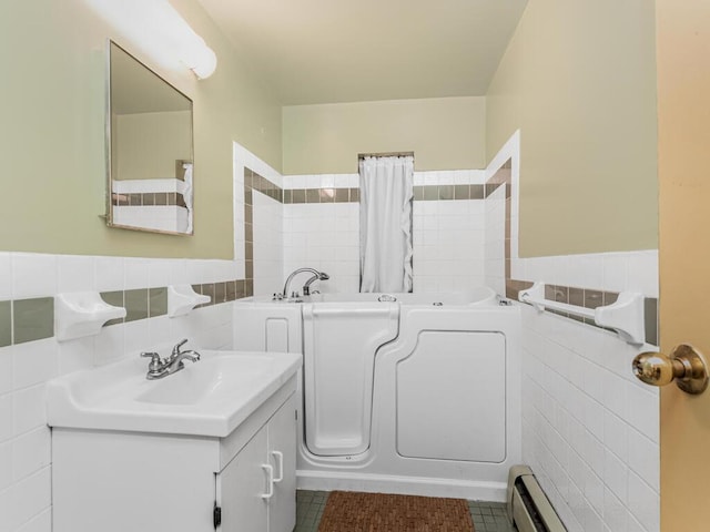 bathroom featuring a tub, tile patterned floors, tile walls, and vanity