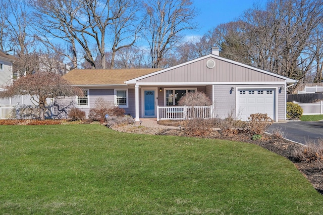 ranch-style house with a front yard, fence, covered porch, a garage, and aphalt driveway