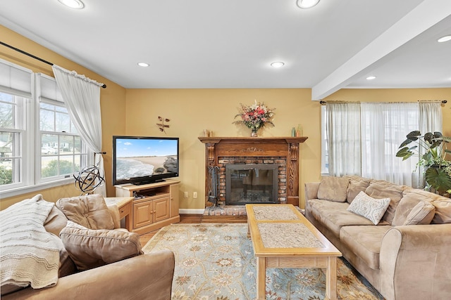 living room featuring baseboards, a brick fireplace, beam ceiling, and recessed lighting