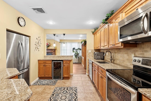 kitchen featuring visible vents, decorative backsplash, wine cooler, appliances with stainless steel finishes, and a sink