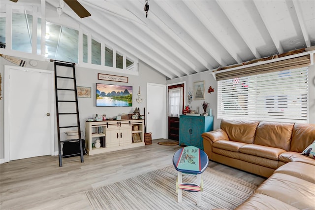 living room featuring vaulted ceiling with beams and light wood-style flooring