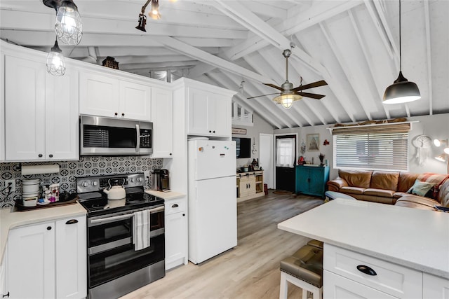 kitchen featuring vaulted ceiling with beams, stainless steel appliances, light countertops, open floor plan, and white cabinets