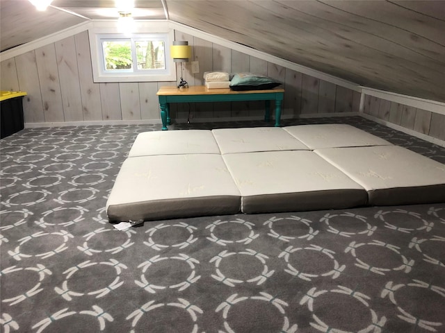 bonus room with wooden walls, baseboards, and vaulted ceiling