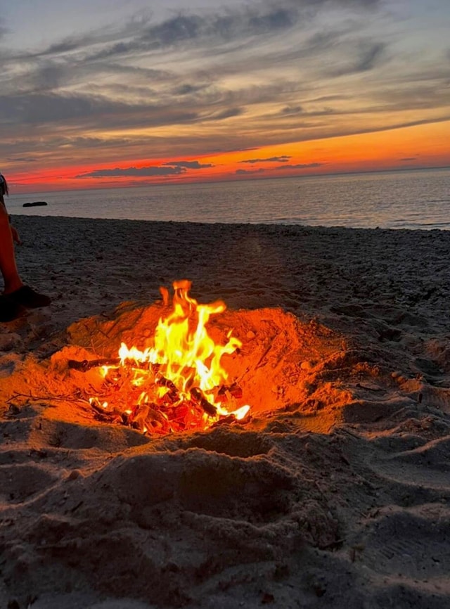 water view with a fire pit and a beach view