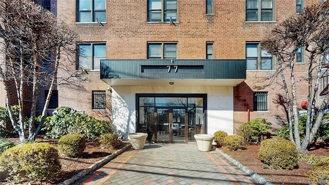 view of exterior entry with french doors and brick siding