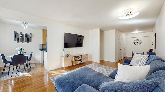 living area featuring light wood finished floors and baseboards