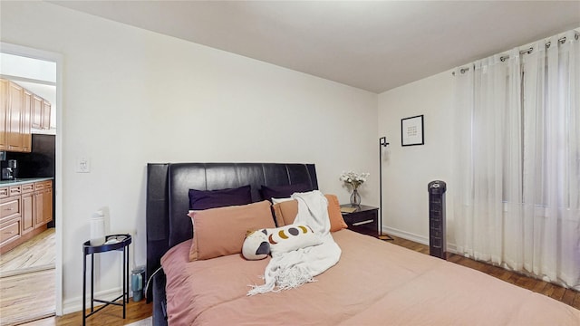 bedroom with light wood-style flooring and baseboards