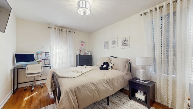 bedroom with baseboards and wood finished floors