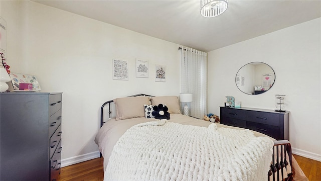 bedroom with dark wood-style floors and baseboards