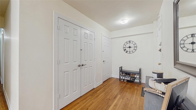 hall with baseboards and light wood-style floors