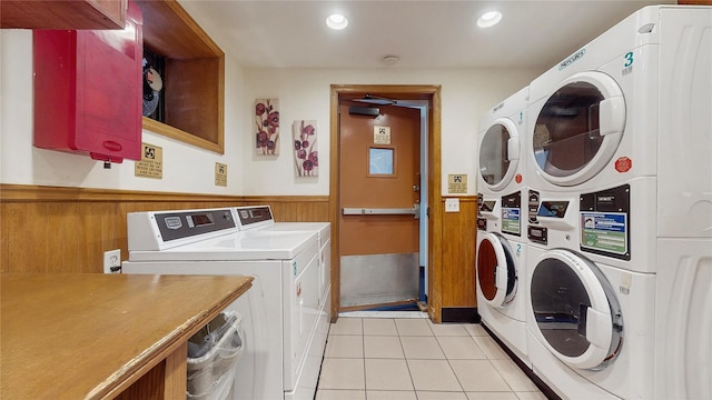 community laundry room featuring a wainscoted wall, washer and clothes dryer, light tile patterned floors, stacked washer / drying machine, and recessed lighting