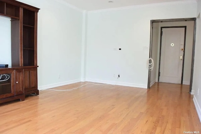 unfurnished living room featuring light wood-style flooring, baseboards, and crown molding