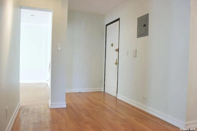 unfurnished bedroom featuring light wood-style flooring, electric panel, and baseboards