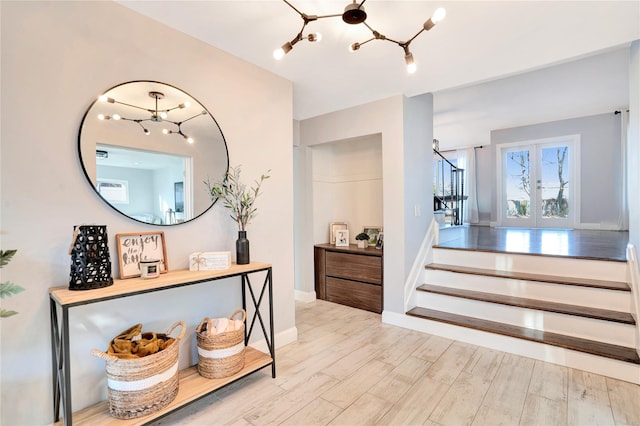 interior space featuring a chandelier, french doors, stairway, and wood finished floors