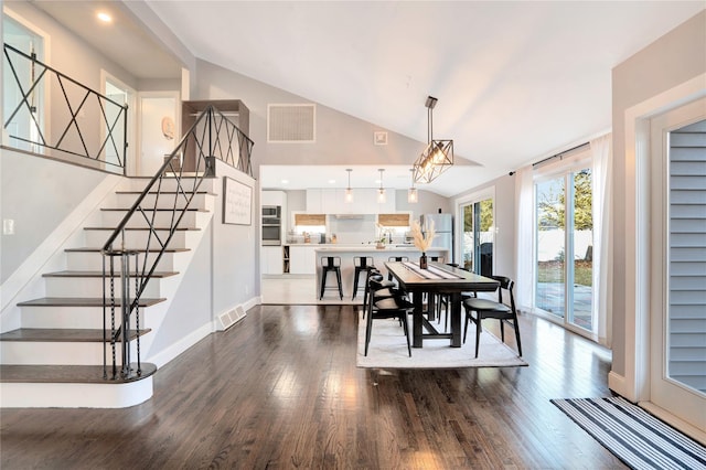 dining room with vaulted ceiling, visible vents, and dark wood finished floors