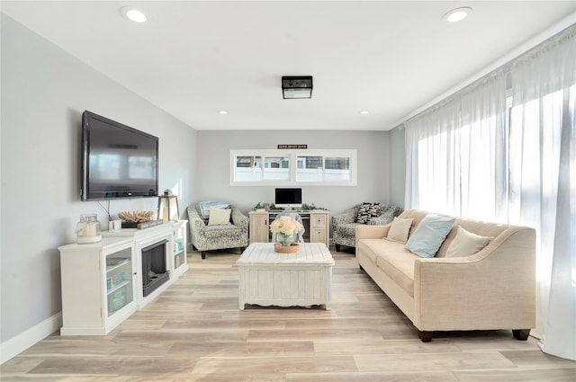 living area featuring baseboards, light wood-style flooring, and recessed lighting