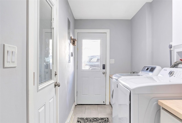 clothes washing area with laundry area, light tile patterned flooring, and independent washer and dryer